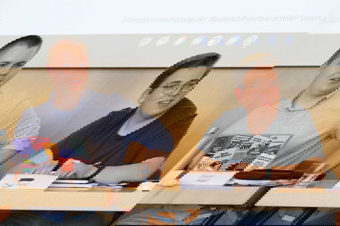 Zwei junge als Männer lesbare Personen leiten eine Sitzung.