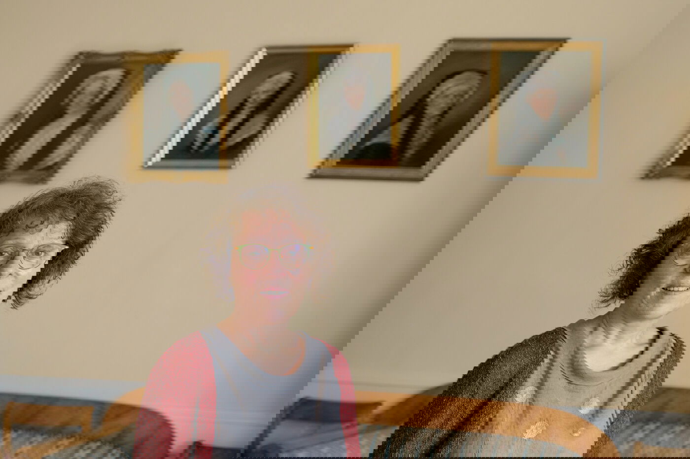 Eine Frau steht vor historischen Portraits.