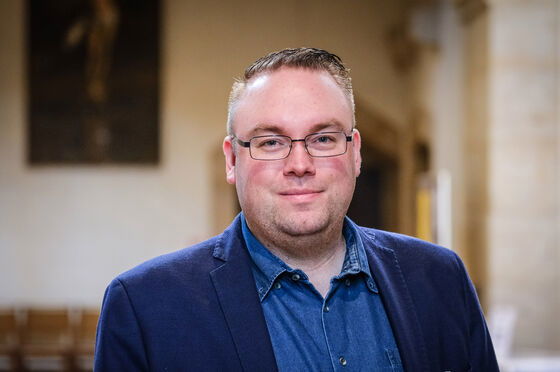 Eine Person mit Brille schaut in die Kamera