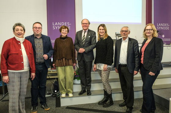 Mehrere Personen stehen zusammen und lächeln in die Kamera