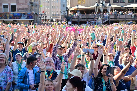 Eine große Menschenmenge steht auf einem Platz und jubelt.