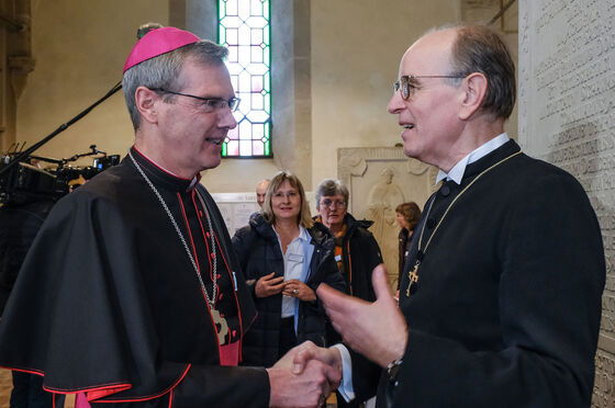 Zwei als Männer und Geistliche lesbare Personen reden miteinander.