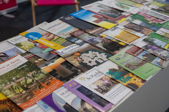 Ein Tisch voller unterschiedlicher Gemeindebriefe. 