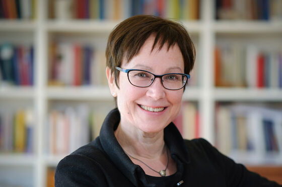 Eine weiblich zu lesende Person mit Brille lächelt in die Kamera.