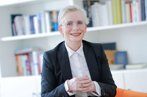 Eine weiblich zu lesende Person schaut lächelnd in die Kamera.