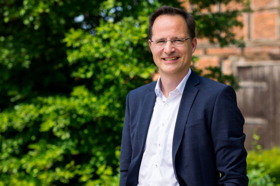 Eine männlich  zu lesende Person mit Brille schaut in die Kamera