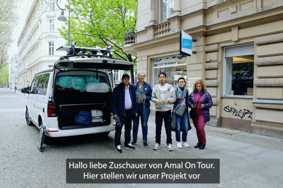 Fünf Menschen stehen neben einem Van, dessen Heckklappe offen ist.