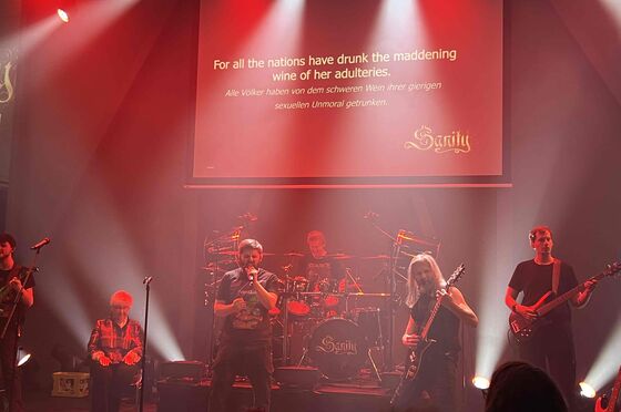 Eine Band spielt auf einer rot ausgeleuchteten Bühne