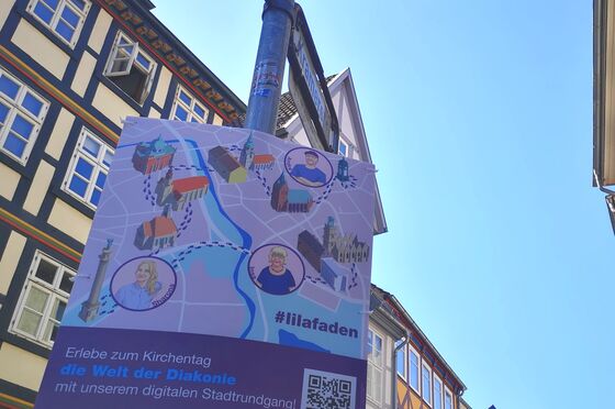 Ein Plakat an einem Straßenschild, das einen Stadtplan zeigt mit verschiedenen Illustrationen darauf.