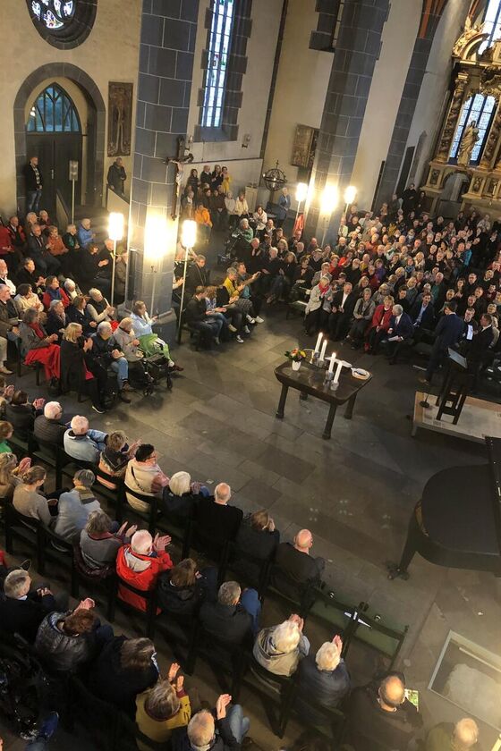 Viele Menschen sitzen in einer Kirche.