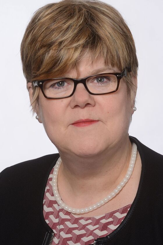 Eine als Frau lesbare Person mit kurzen Haaren und Brille.