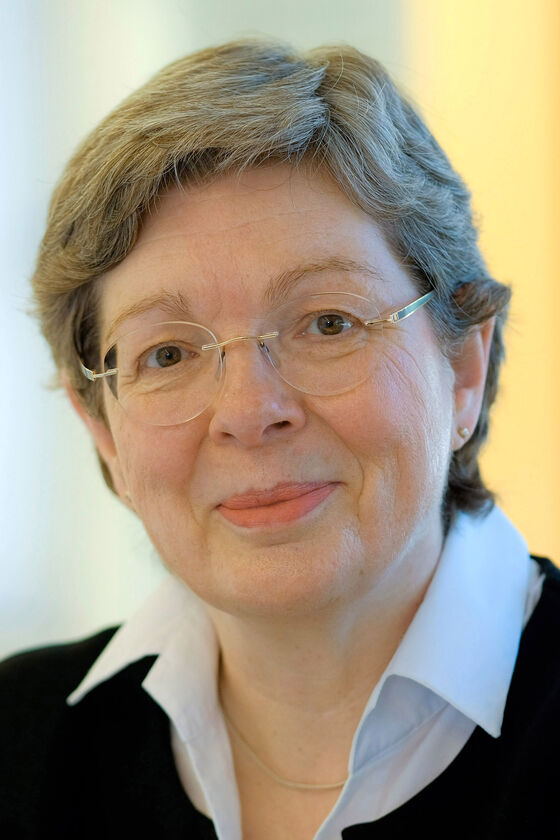 Eine als Frau lesbare Person mit grauen Haaren und Brille
