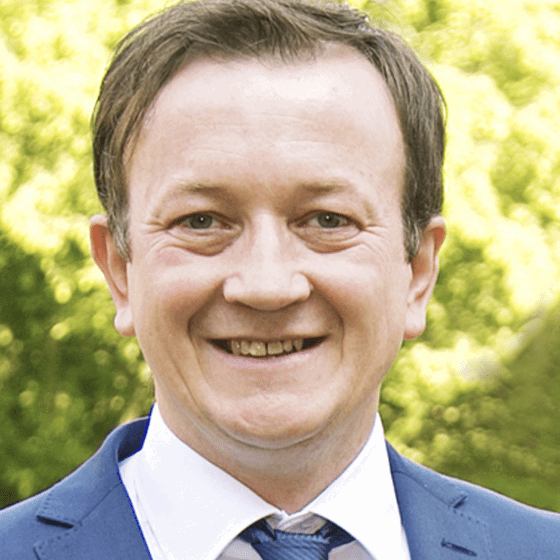 ein Mann laechelt in die Kamera