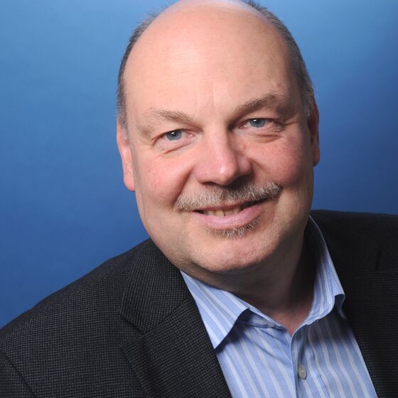 Eine männlich gelesene Person im Anzug.