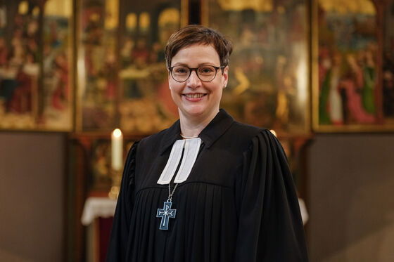 Eine weiblich zu lesende Person im Talar.