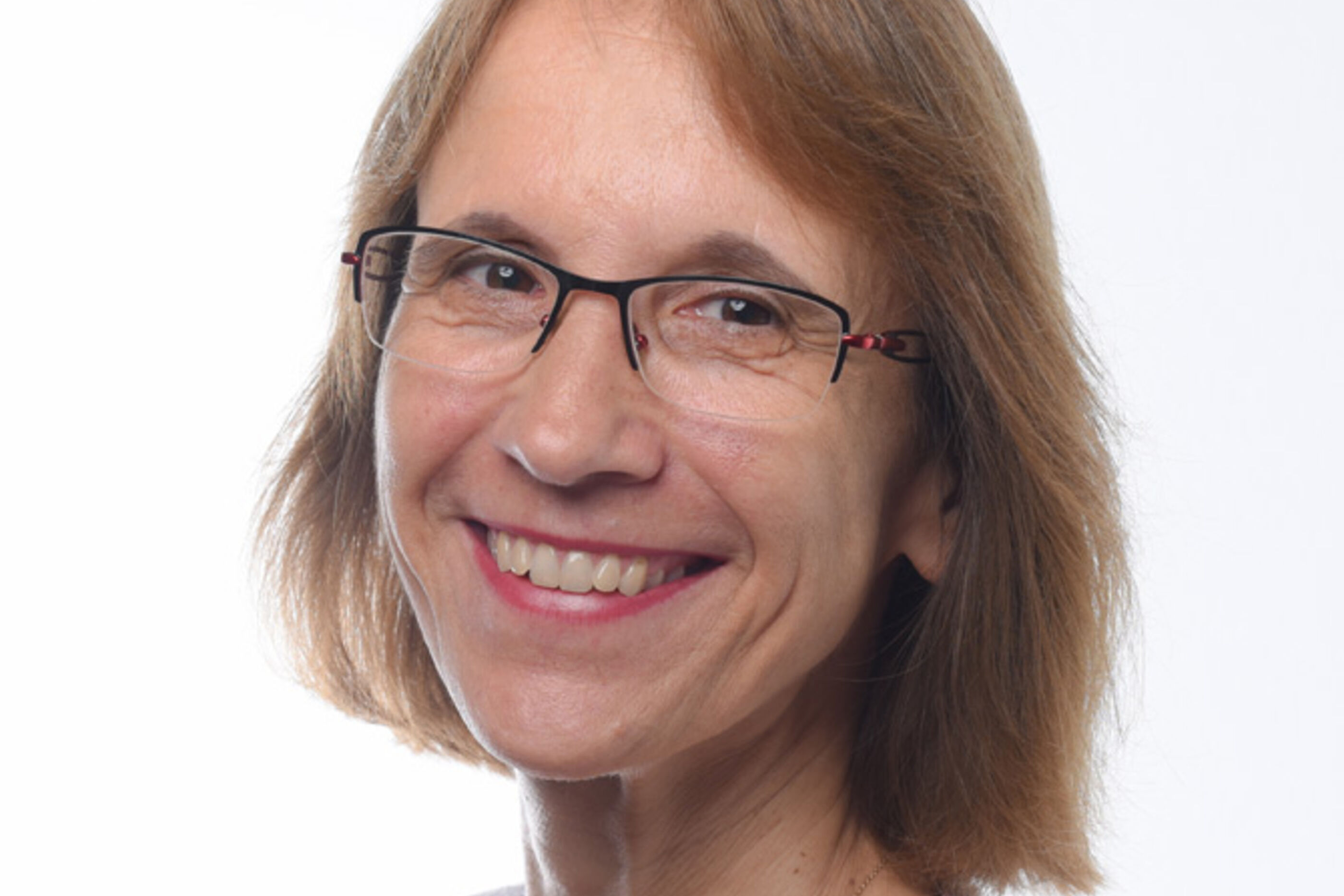 Eine als Frau lesbare Person mit Brille und schultelangen Haaren