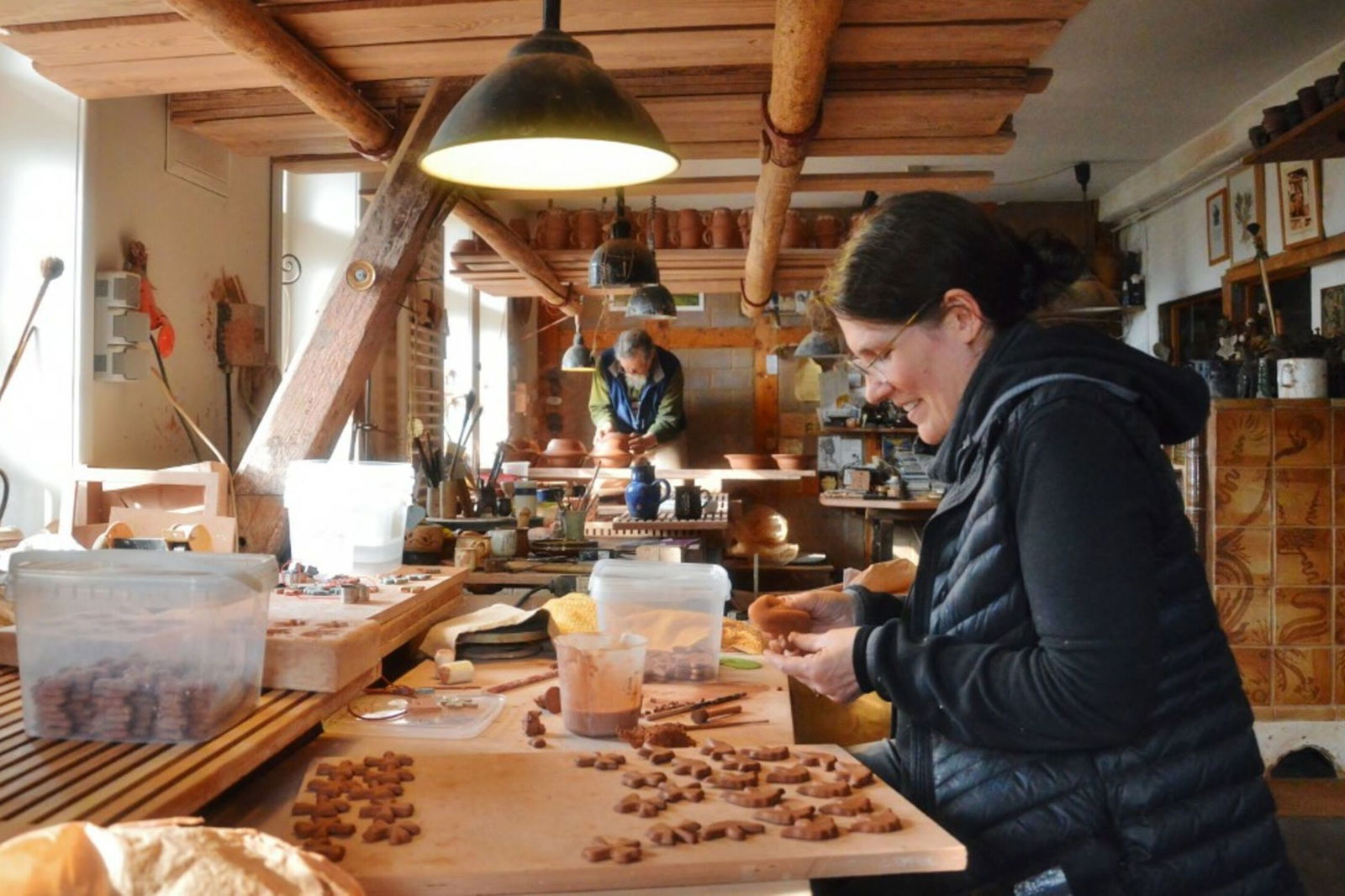 Eine Frau arbeitet mit Ton in einer Werkstatt.