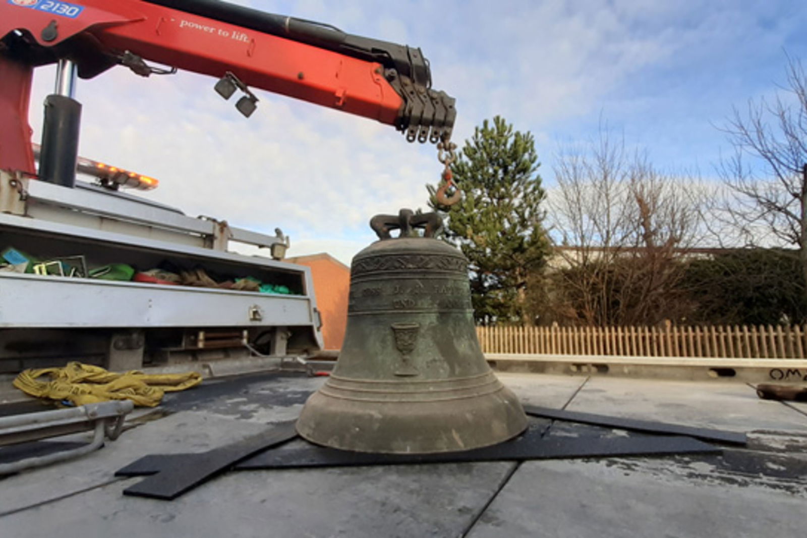 Ein Kirchenglocke und ein Bagger. 