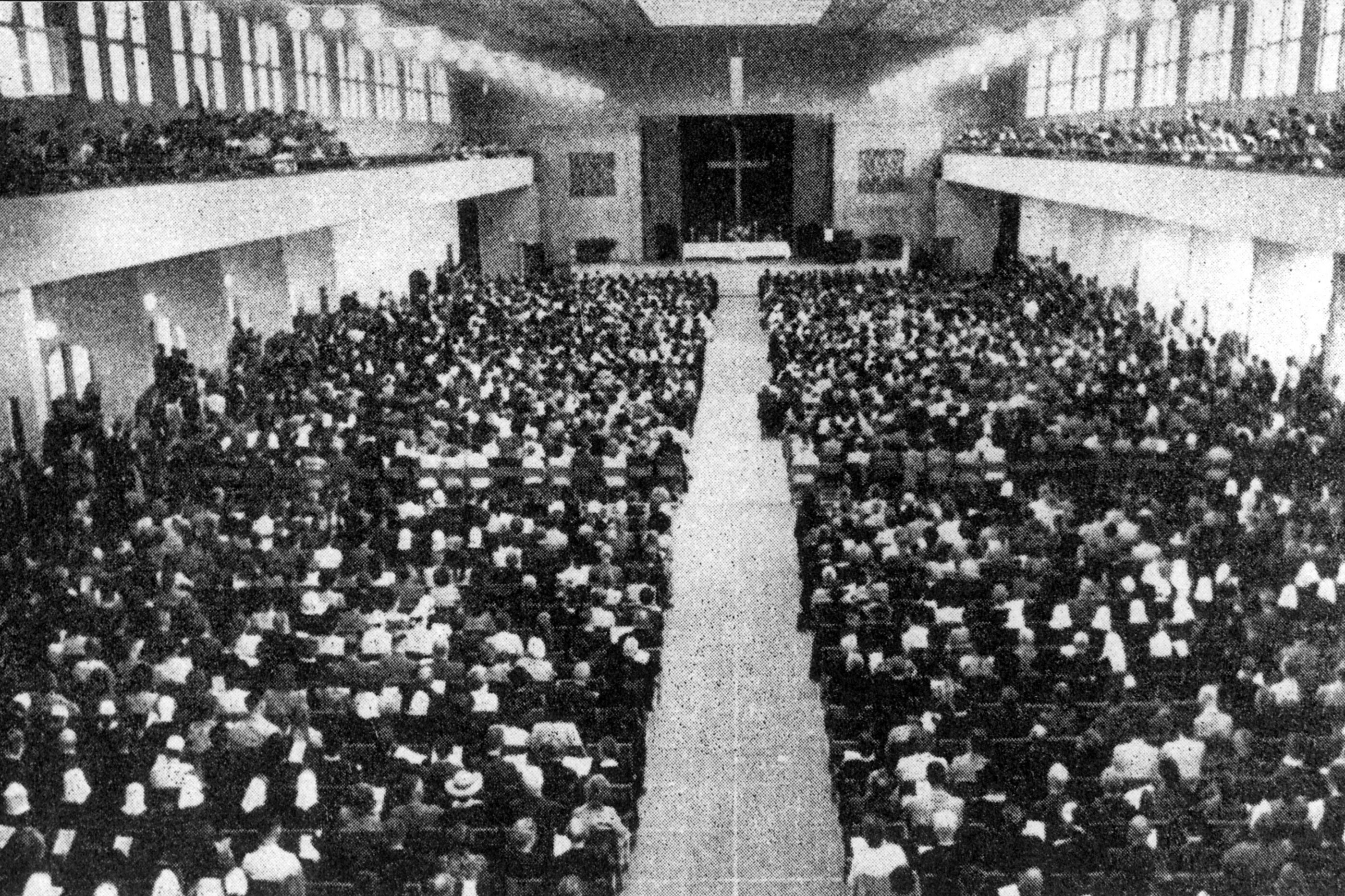 Historisches Schwarzweiß-Foto einer großen Veranstaltung in einer Halle.