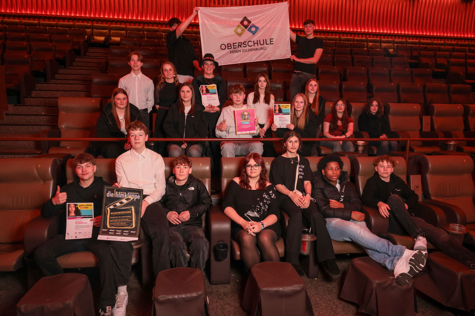 Etwa ein Dutzend junge Menschen sitzen in Kinosesseln.
