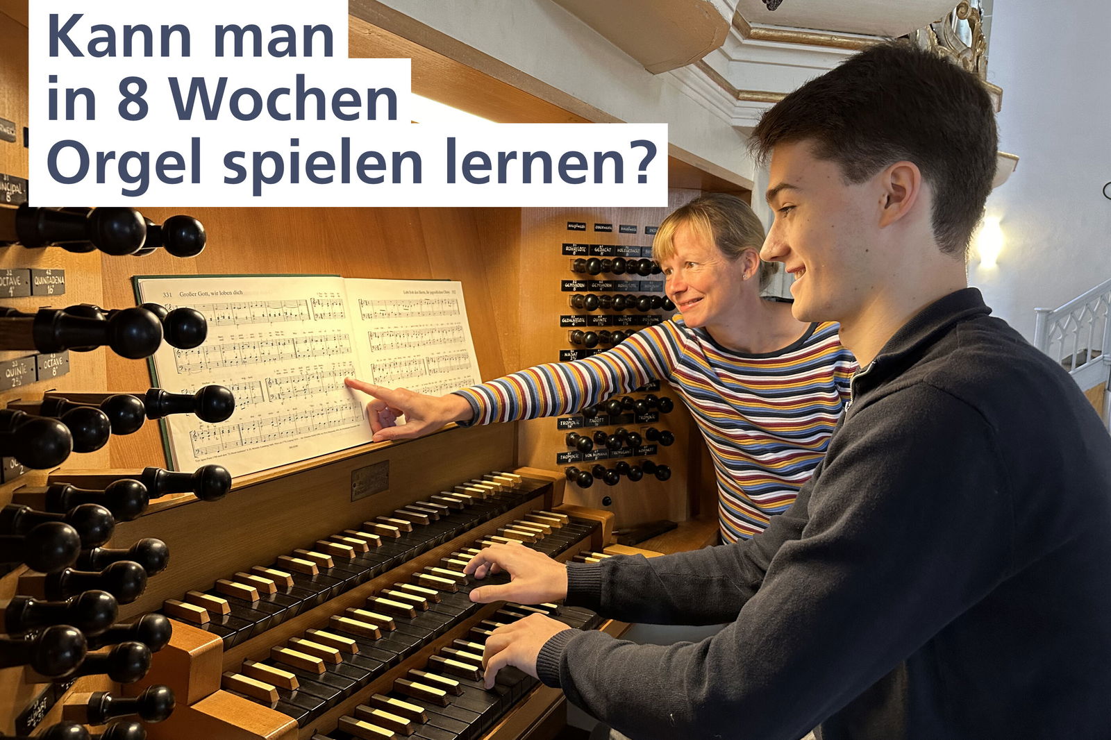 Zwei Menschen sitzen an einer Orgel.