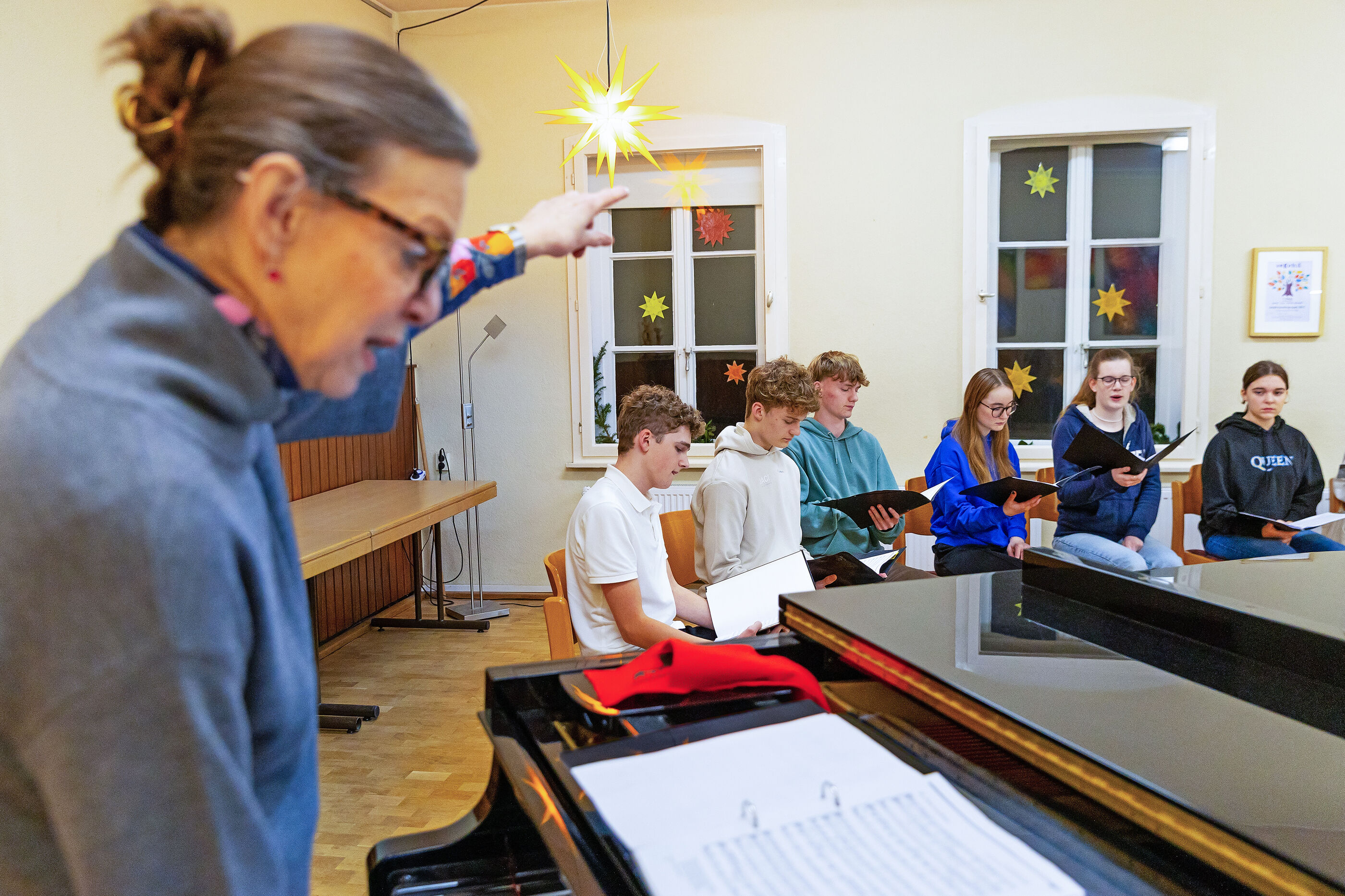 Eine Frau am Klavier dirigiert.