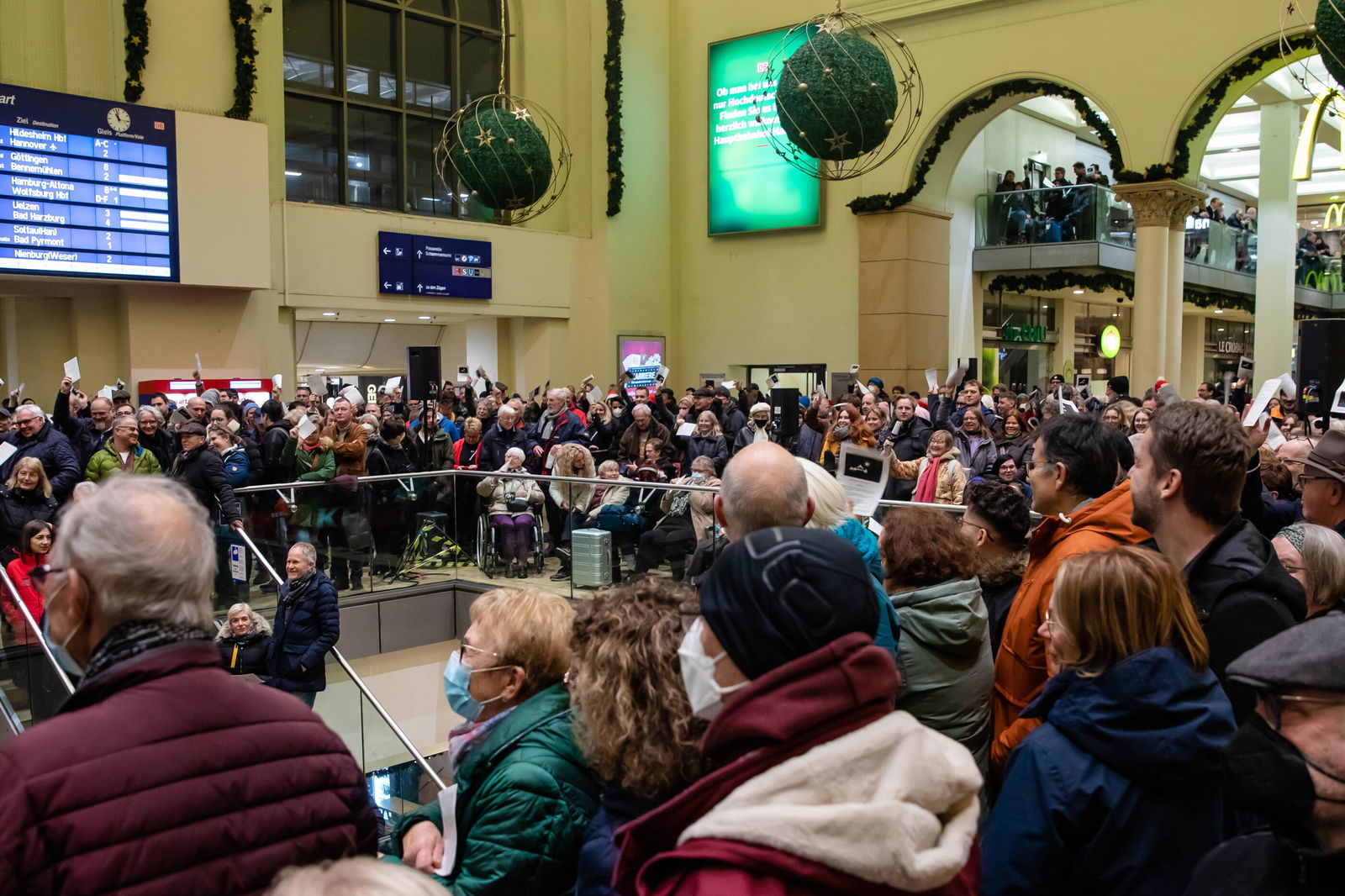 Menschen stehen in einer Bahnhofshalle