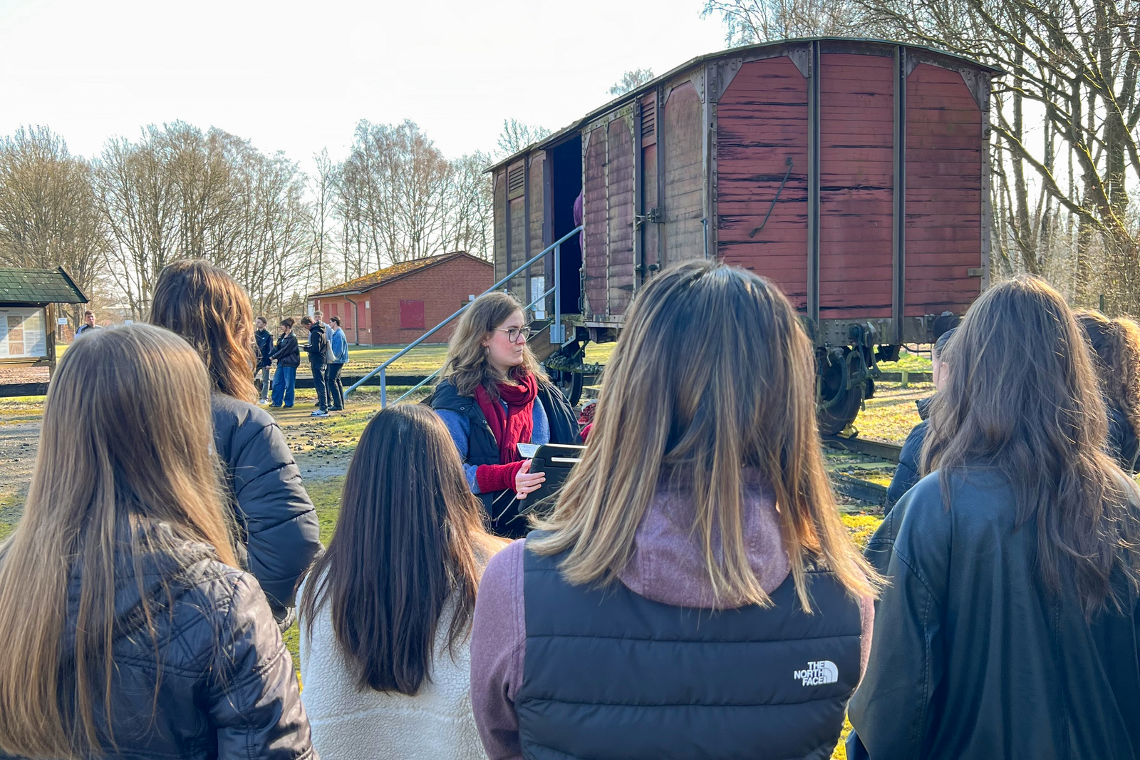 Mehrere junge Menschen stehen draußen zusammen an einem Bauwagen.