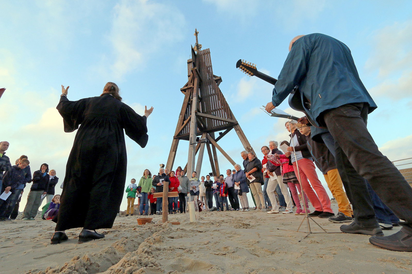 Eine Gruppe feiert eine Andacht am Strand.