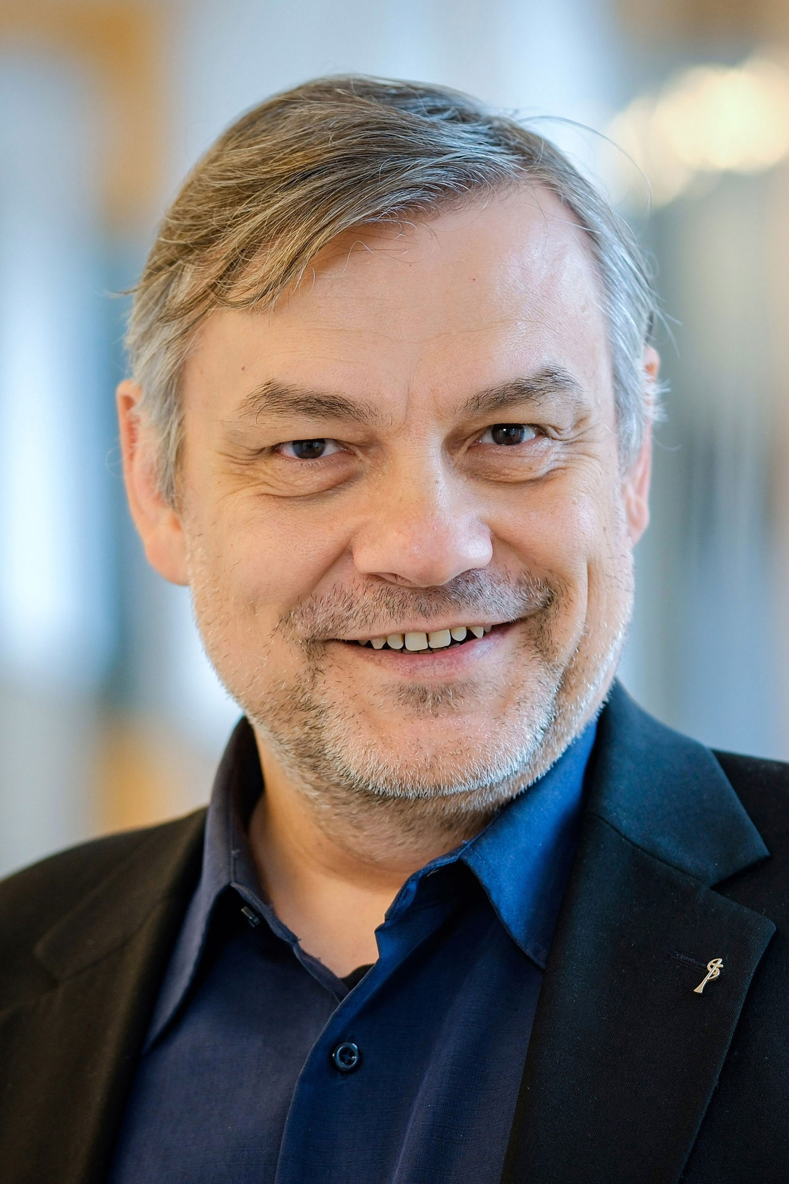 Ein Mann mittleren Alters lächelt.