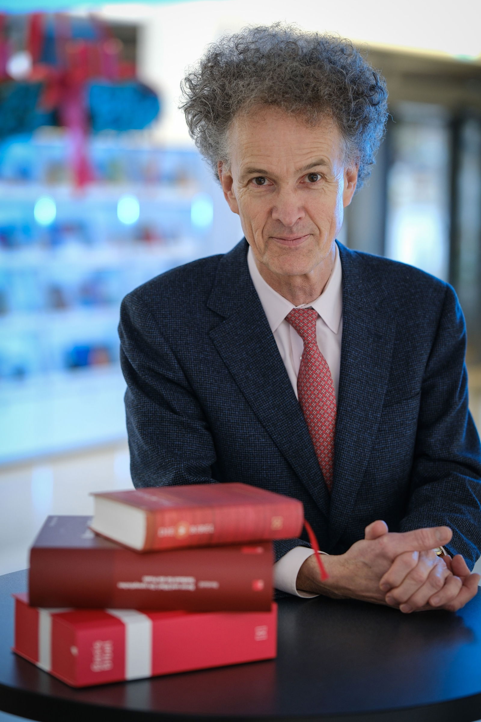 Ein Mann im Anzug vor Büchern