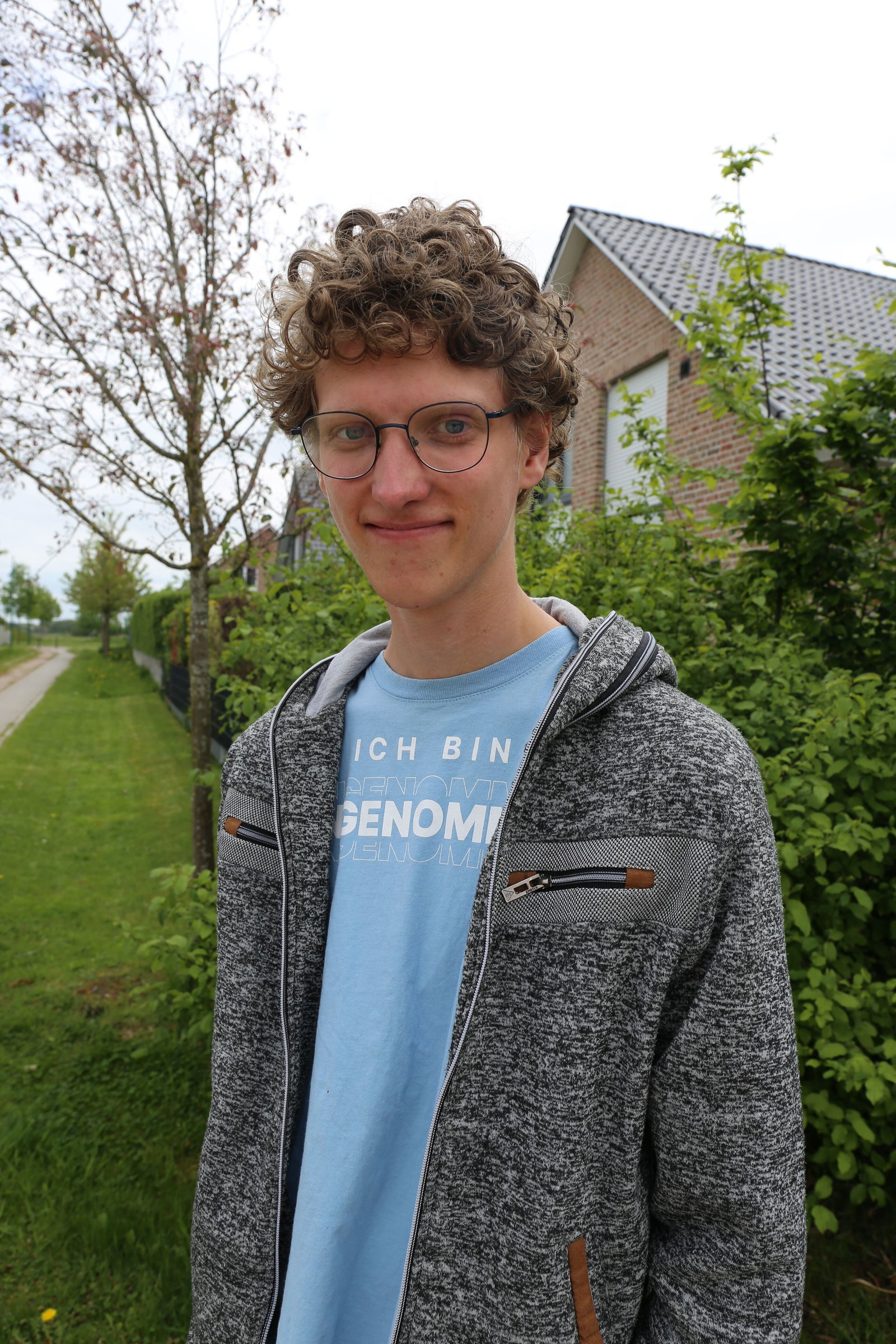 Ein Mann mit Locken und Sweatshirtjacke.