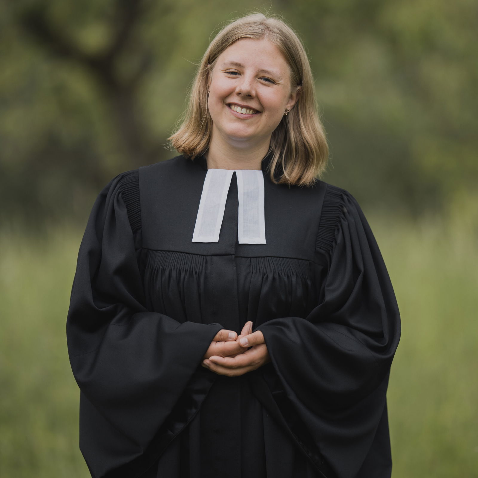 eine weiblich gelesene Frau in einem Talar