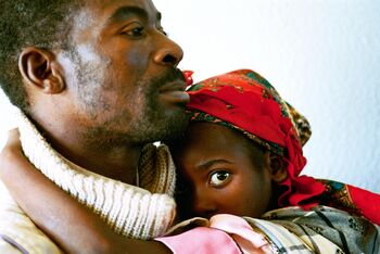 Ein Mann hält seine Tochter in einem Krankenhaus in Zimbabwe fest im Arm. Foto: Eric Miller, World Bank Photo Collection, CC BY 2.0