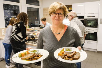 Bettina Nebe mit dem Hauptgang: Nussbraten, marinierte Mischpilze und Rosenkohl-Kürbis-Spieße mit Pesto. Ein Weihnachtsessen ganz ohne Fleisch – d​as ist der Plan bei einem Kochkurs in der Familien-Bildungsstätte. Foto: epd-bild/Jens Schulze