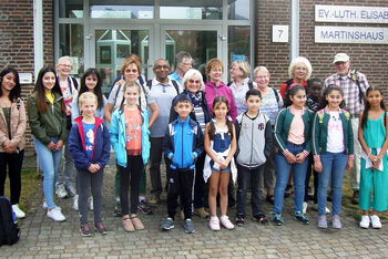 Inge Collatz (Mitte, mit Halstuch), ehrenamtlich Mitarbeitende der Lernhilfe und die Kinder und Jugendlichen im Jahr 2020 vor dem Gemeindehaus der Elisabethkirche. Foto: Archiv