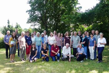 Eine Gruppe von Menschen steht in einem Park. Sie tragen Sommerkleidung. Das Foto zeigt die Schoepfungsbotschafterinnen.