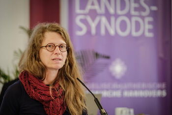 Eine weiblich lesbare Person an einem Mikrofon