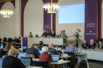 Mehrere Personen in einem Sitzungssaal