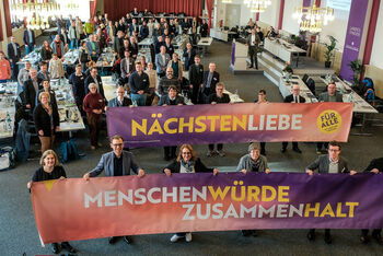 Viele Personen halten Banner mit der Aufschrift Nächstenliebe, Menschenwürde, Zusammmenhalt