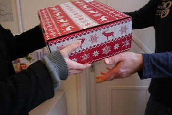 Ein Paket wird von einer zu einer anderen Person übergeben.