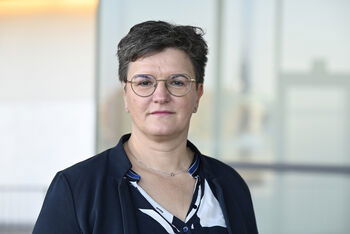 Portraitfoto einer als Frau lesbaren Person mit kurzen Haaren.