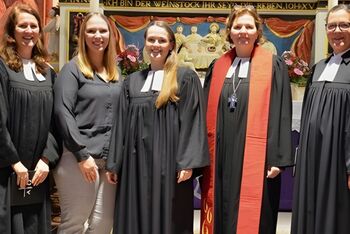 Frauen im Ornat vor einem Altar.