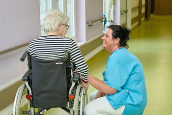 Pflegekraft mit einer Bewohnerin in einem Pflegeheim.