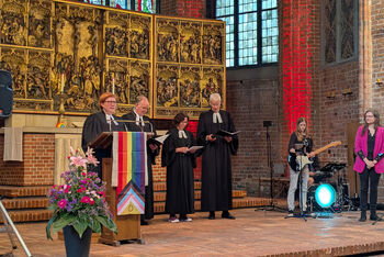 Mehrere Menschen im Altarraum einer Kirche.