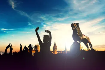 Eine Silhouette mit feiernden Menschen und dem Wappentier Braunschweigs, dem Löwen.
