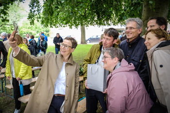 Mehrere als Männer und Frauen lesbare Personen machen ein Selfie.