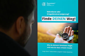 Eine als Mann lesbare Person schaut auf einen Bildschirm, auf dem die Titelseite der Broschüre „Finde deinen Weg“ zu sehen ist.