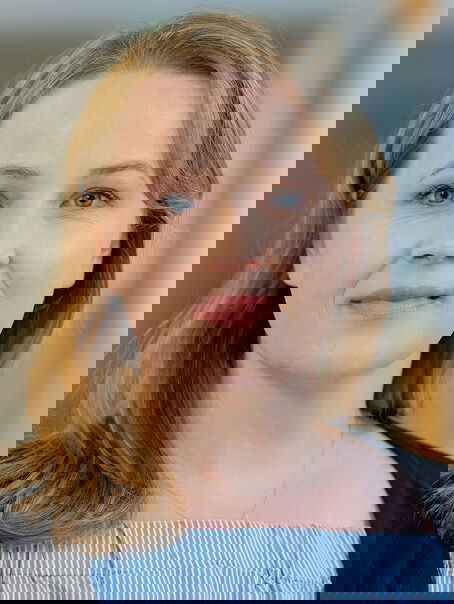 Das Bild zeigt eine weiblich lesbare Person mit schulterlangen mittelblonden Haaren und einem hellblauen Oberteil.