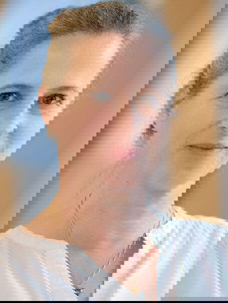 Eine weiblich gelesene Person mit weißer Bluse und hochgesteckten mittelblonden Haaren.